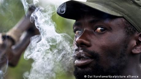A Mai Mai militiaman smokes a cigarette.