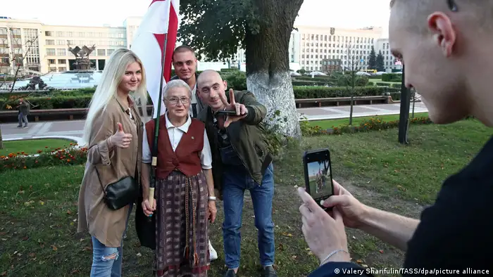 Aktivistin Nina Baginskaja posiert mit drei weiteren, jüngeren Landsleuten für ein Foto. Sie trägt die Flagge der belarussischen Protestbewegung.