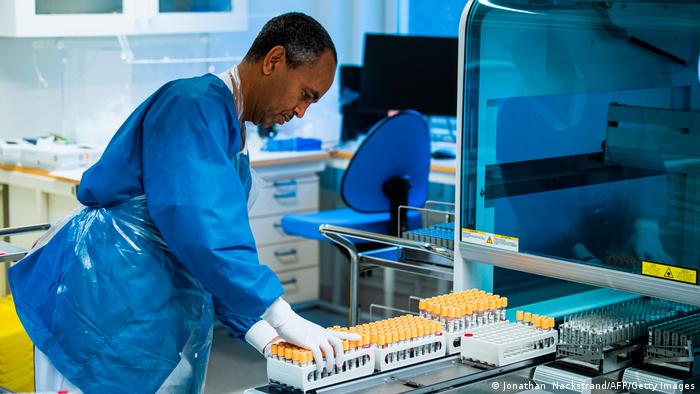 Ein Laborant führt Proben in eine PCR-Maschine am Karolinska Hospital in Solna/Schweden ein. 