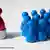 ymbolbild zum Thema Gruppe mit Anführer: Blaue Spielfiguren stehen aufgereiht vor einem einzelnen roten Spielsteinchen auf einem Podest. Aufnahme vom 05.05.2009. Foto: Robert B. Fishman +++(c) dpa - Report+++