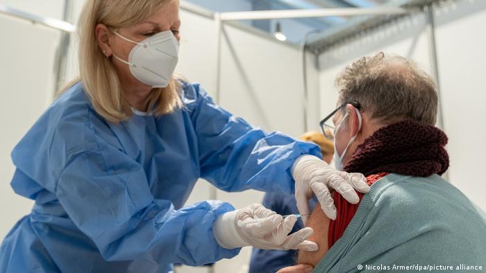 Сотрудница медицинского центра в Бамберге, Бавария, демонстрирует, как будут делать прививку от коорнавируса 