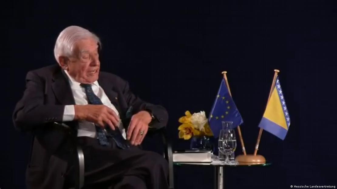 Christian Schwarz-Schilling sjedi a pored njega na stolu zastave EU i BiH