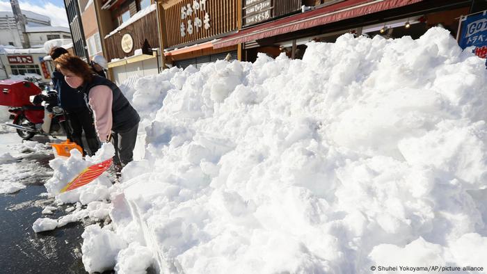 A Japanese woman shovels snow