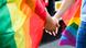 Two hands entwined, surrounded by rainbow flags Two hands entwined, surrounded by rainbow flags