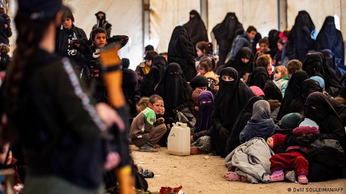 A guard keeps watch over women and children at the Kurdish-run al-Hol internment camp