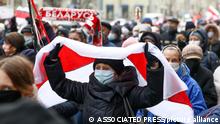 16.11.2020 A woman covers herself by an old Belarusian national flag attends a pensioners' opposition rally to protest the official presidential election results in Minsk, Belarus, Monday, Nov. 16, 2020. Crowds of retirees marched down the streets of the Belarusian capital on Monday, demanding the resignation of the country's authoritarian president and to end the government crackdown on peaceful protesters. (AP Photo)
