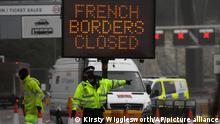 A police officer directs traffic at the entrance to the closed ferry terminal in Dover, England, Monday, Dec. 21, 2020, after the Port of Dover was closed and access to the Eurotunnel terminal suspended following the French government's announcement. France banned all travel from the UK for 48 hours from midnight Sunday, including trucks carrying freight through the tunnel under the English Channel or from the port of Dover on England's south coast. (AP Photo/Kirsty Wigglesworth)