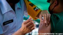 A medical personnel injects the vaccine against influenza to a military during a full-scale mock drill for mass vaccination against COVID-19 at the 81st Infantry Battalion in Mexico City, on December 18, 2020. - Some 120 military personnel served as volunteers Friday for a covid-19 vaccine transfer and application trial organized by the Mexican government, the Army, Pfizer personnel and a private delivery company in Mexico City. (Photo by CLAUDIO CRUZ / AFP) (Photo by CLAUDIO CRUZ/AFP via Getty Images)