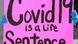 A woman holds a sign that reads "COVID-19 is a life sentence" A woman holds a sign that reads "COVID-19 is a life sentence"