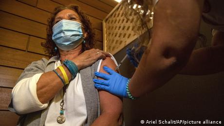 Woman in Israel getting vaccinated before the country rescinded the mandatory wearing of facemasks
