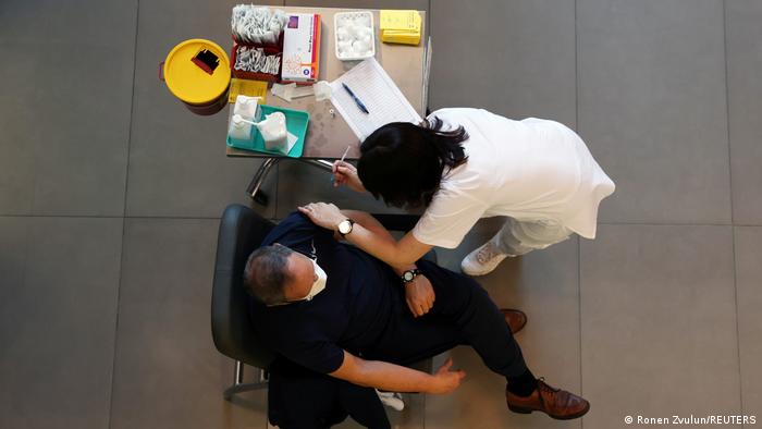 Ein medizinischer Mitarbeiter impft einen Mann gegen die Coronavirus-Erkrankung (COVID-19) 