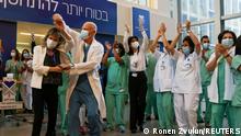 Medical teams celebrate before receiving coronavirus disease (COVID-19) vaccines as Israel kicks off a coronavirus vaccination drive, at Tel Aviv Sourasky Medical Center (Ichilov Hospital) in Tel Aviv, Israel December 20, 2020. REUTERS/Ronen Zvulun TPX IMAGES OF THE DAY