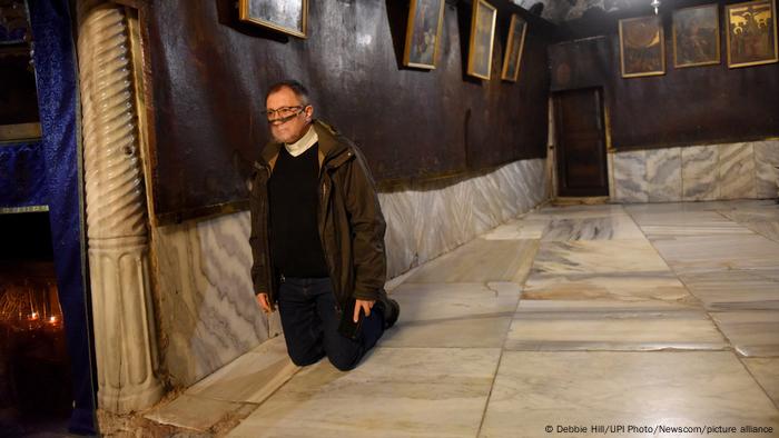 El sacerdote lleva una máscara facial en la Iglesia de la Natividad