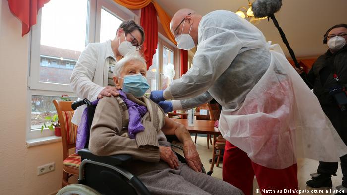 Ein Arzt und eine Helferin impfen die 101 Jahre alte Heimbewohnerin Edith Kwoizalla in einer Pflegeeinrichtung für Senioren in Halberstadt