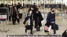 Passengers wearing masks arrive at Fukuoka Airport in Tokyo on Dec. 26, 2020. Year-end and New Year vacations started at some companies on the same day, however, to avoid infections of novel coronavirus COVID-19, passengers fewer than usual year were seen at stations and airports to go home or to travel. ( The Yomiuri Shimbun via AP Images )