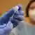 Impfbeginn in Deutschland: Ein Arzt füllt eine Spritze mit dem Impfstoff auf