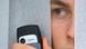 A man is seen through a gap in the blinds, holding a camera-mobile phone A man is seen through a gap in the blinds, holding a camera-mobile phone