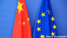 (FILES) In this file photograph taken on June 29, 2015, a Chinese flag (L) is draped beside the European Union (EU) flag during a EU-China Summit at European Union Commission headquarters in Brussels. - EU member states give political backing to Brussels' efforts to negotiate an investment pact with China on December 28, 2020, diplomats said, clearing the way for a deal. At a meeting of ambassadors, one said, the German EU presidency noted no member had raised a stop sign and the way for a political endorsement was thus cleared. (Photo by THIERRY CHARLIER / AFP)
