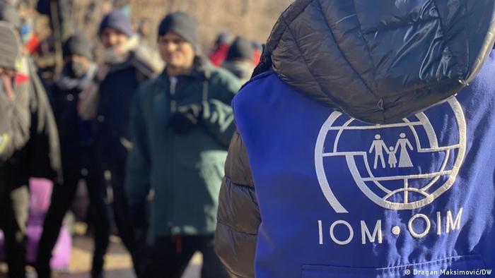 Ein IOM-Mitarbeiter beobachtet Migranten am 30.12.2020 in der Nähe der abgebrannten Camps Lipa in Westbosnien. Die IOM hatte das Camp zuvor verlassen, weil die bosnischen Behörden Lipa nicht winterfest gemacht hatten. Anschließend kam es in dem Camp zu Bränden