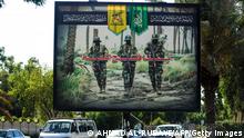 A picture taken on June 20, 2018 shows a propaganda billboard for the pro-Iran Hezbollah Brigades militia hanging over Palestine Street in the centre of the Iraqi capital Baghdad, depicting three of their masked fighters walking along a road between palm trees. - Iraqi police on June 20 surrounded the militia's Baghdad headquarters after an armed clash with law enforcement left three people wounded.
Hezbollah Brigades is part of the Hashed al-Shaabi paramilitary units that fought against IS in Iraq, and is also independently fighting on the side of Bashar al-Assad's government in Syria. (Photo by AHMAD AL-RUBAYE / AFP) (Photo credit should read AHMAD AL-RUBAYE/AFP via Getty Images)