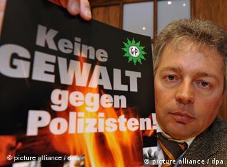Der niedersächsische Vorsitzende der Gewerkschaft der Polizei (GdP), Bernhard Witthaut, hält ein Plakat hoch, auf dem 'Keine Gewalt gegen Polizisten!' steht (Foto: dpa)