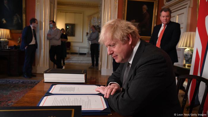 Boris Johnson signe un accord sur le Brexit sous le regard de David Frost