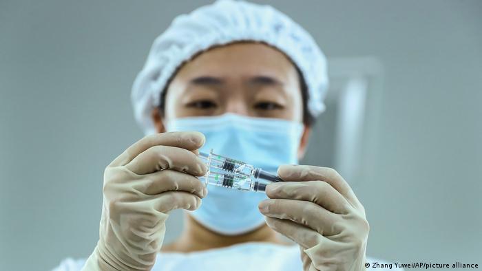 A woman holds Chinese Sinopharm vaccines.