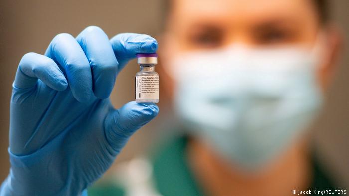 A medical professional holds the BioNTech/Pfizer vaccine in his hand