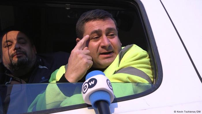 Italian truck driver putting his finger to his temple