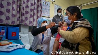 Врач делает укол тестовой вакциной женщине в Нью-Дели