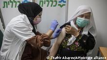 A Bedouin woman receives a Pfizer COVID-19 vaccine at a medical center in the Bedouin local council of Segev Shalom near the city of Beersheba, southern Israel, Wednesday, Dec. 30, 2020. (AP Photo/Tsafrir Abayov)