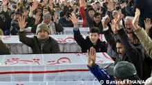 Mourners from Shiite Hazara community chant slogans near the coffins of the miners who were killed in an attack by gunmen in the mountainous Machh area, during a sit-in protest at the eastern bypass, on the outskits of Quetta on January 4, 2021. - Thousands of mourners from Pakistan's minority Shiite community on January 4 protested alongside the bodies of miners killed in an attack claimed by the Islamic State group. (Photo by Banaras KHAN / AFP)