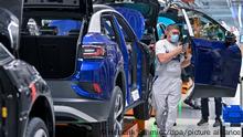 Ein Mitarbeiter im Volkswagenwerk in Zwickau komplettiert einen VW ID.4. Volkswagen produziert im Werk in Zwickau das erste reine Elektro-SUV. Hier läuft bereits der ID.3 vom Band. Von den bis 2025 jährlich geplanten 1,5 Millionen E-Fahrzeugen der Marke werden etwa 500.000 Einheiten für den ID.4 erwartet.