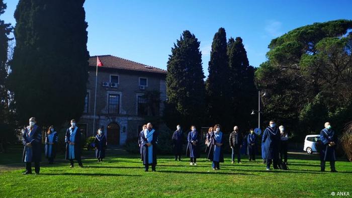 People standing on a lawn with their backs to the rectory at Bogazici University