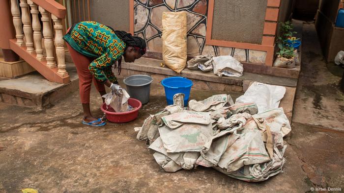 A woman washes plastic wrap in a vat in Mpigi, Uganda