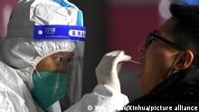 (210106) -- SHIJIAZHUANG, Jan. 6, 2021 (Xinhua) -- A medical worker collects a swab sample from a resident at a community in Yuhua District of Shijiazhuang, capital of north China's Hebei Province, Jan. 6, 2021. Shijiazhuang started to conduct citywide nucleic acid tests covering all citizens on Wednesday. (Xinhua/Wang Xiao)