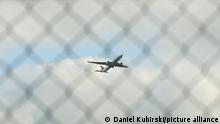 Symbolbild Abschiebeflug / Evakuierung Startender Jet der Lufthansa am Frankfurter Flughafen, Fraport, hinter Maschendrahtzaun.