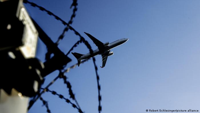 Plane flying above barbed wire