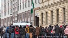 Menschen und ein Polizeifahrzeug vor der nigerianischen Botschaft in Berlin