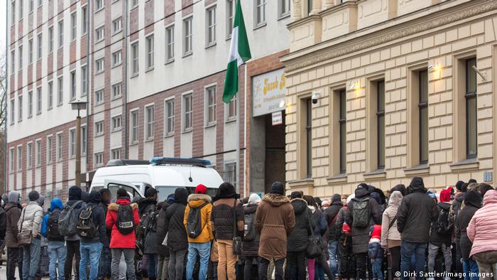 Menschen und ein Polizeifahrzeug vor der nigerianischen Botschaft in Berlin