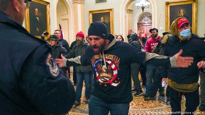 Trump supporters gesture to U.S. Capitol Police in the hallway outside of the Senate chamber
