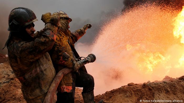 Iraqi fire fighters try to extinguish oil wells set on fire near Mosul by the extremist IS group as it fled the area