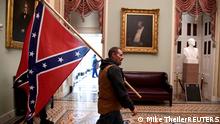 06.01.20121
FILE PHOTO: A supporter of President Donald Trump carries a Confederate battle flag on the second floor of the U.S. Capitol near the entrance to the Senate after breaching security defenses, in Washington, U.S., January 6, 2021. REUTERS/Mike Theiler/File Photo