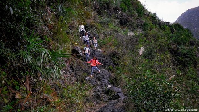 Children climb a rock ladder in the mountains in southern China