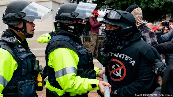 Polizisten und ein Mitglied der Proud Boys stehen sich gegenüber Polizisten und ein Mitglied der Proud Boys stehen sich gegenüber