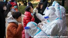 In this photo released by Xinhua News Agency, medical workers in a protective suits take swab from residents near a residential area in Shijiazhuang in north China's Hebei province on Wednesday, Jan. 6, 2021. Lockdown measures were being imposed in a northern Chinese province where coronavirus cases more than doubled in the region near Beijing that's due to host some events in next year's Winter Olympics. (Mu Yu/Xinhua via AP)