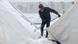 A migrant clears snow from tents at the Lipa camp in Bosnia. A migrant clears snow from tents at the Lipa camp in Bosnia.