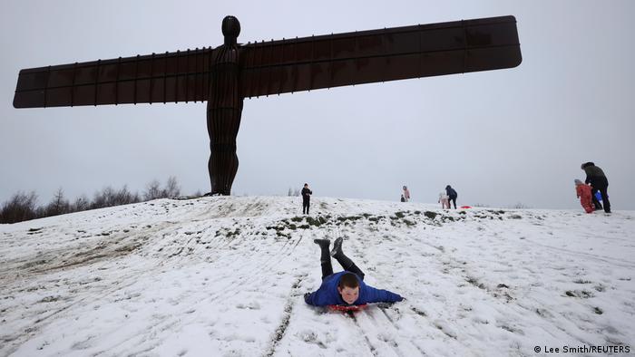 گروهی از کودکان پس از بارش برف روی تپه مشهور به فرشته شمال در این کشور بازی می کنند.