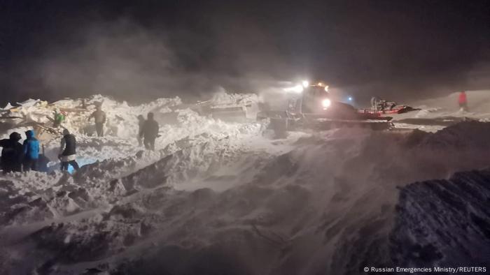 Rescuers and volunteers take part in a search operation after an avalanche hit a ski resort