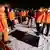 Индонезийские спасатели стоят возле найденных в море обломков самолета